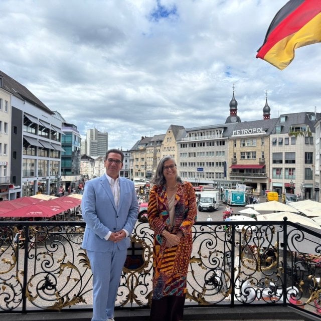 UN-Habitat Executive Director Anacláudia Rossbach and the Lord Mayor of Bonn, Guido Déus, posing together on the steps of the historic Old Town Hall in Bonn, Germany.